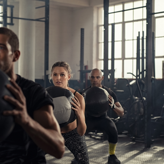 Group of people training with medicine balls in a gym, representing focus, coordination, and peak performance.